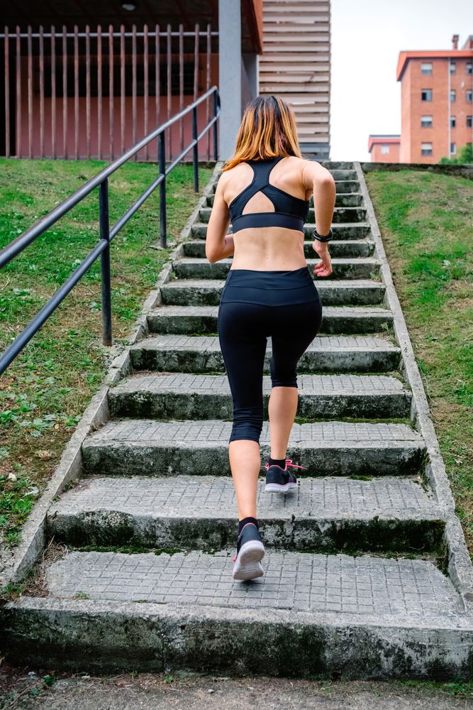 Female athlete climbing stairs outdoors