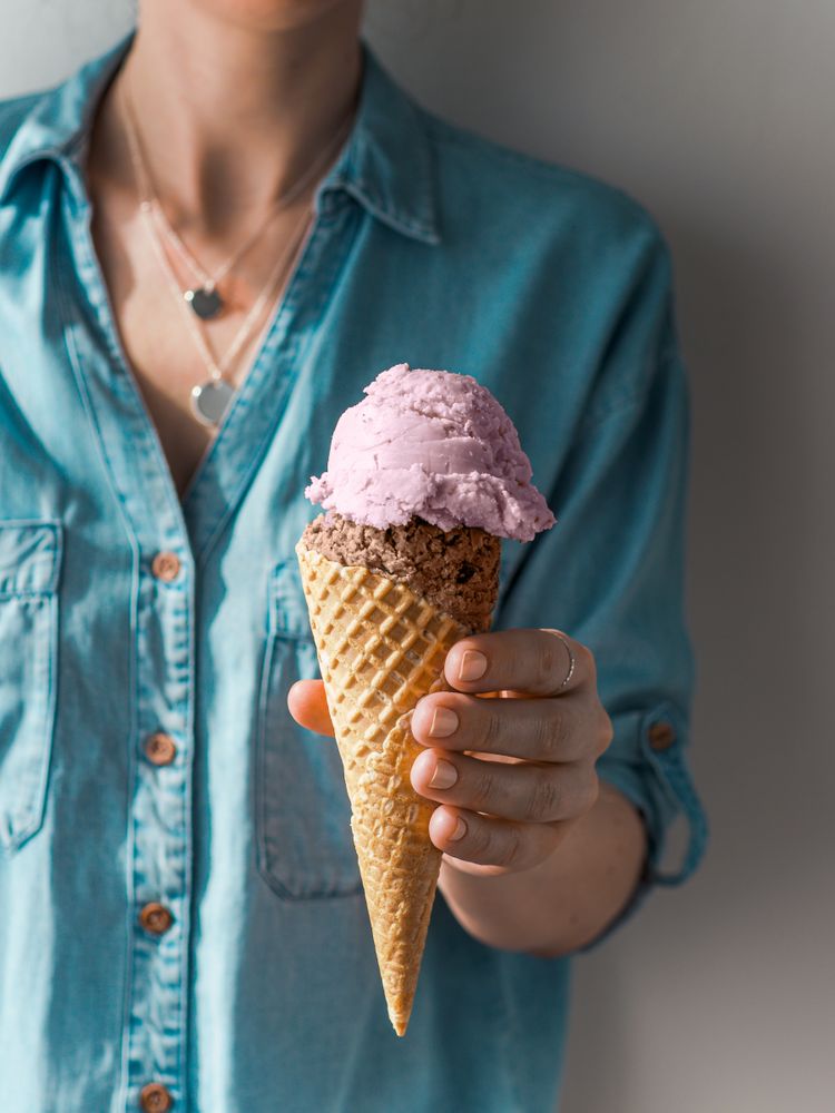 Ice cream scoop in cone in woman hands