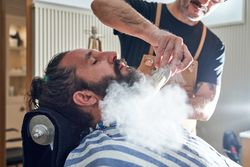 Hairdresser applying powder to customer in barbershop