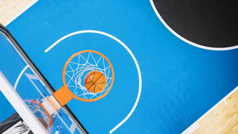 Top Down Shot Of Basketball Ball Going Through a Hoop At Sports Court In International Arena.