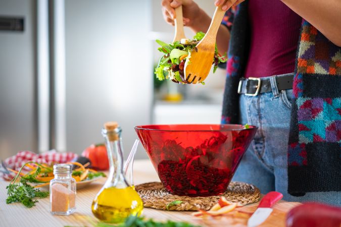 Crop woman preparing vegetable salad