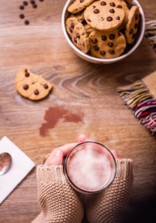 Female hands with hot drink and chocolate cookies