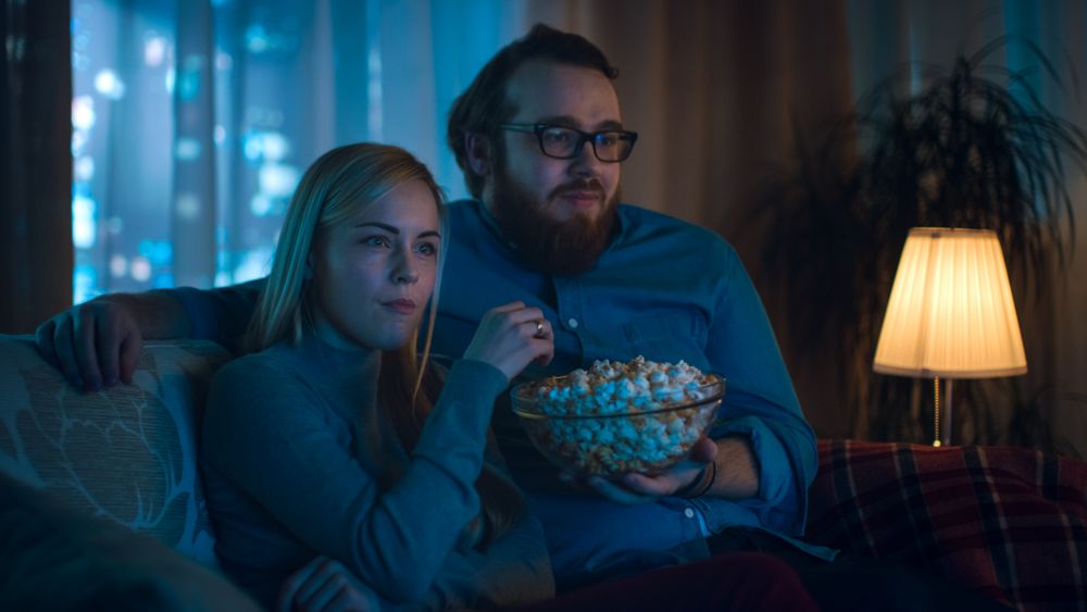 Boyfriend and Girlfriend Watching TV on a Sofa