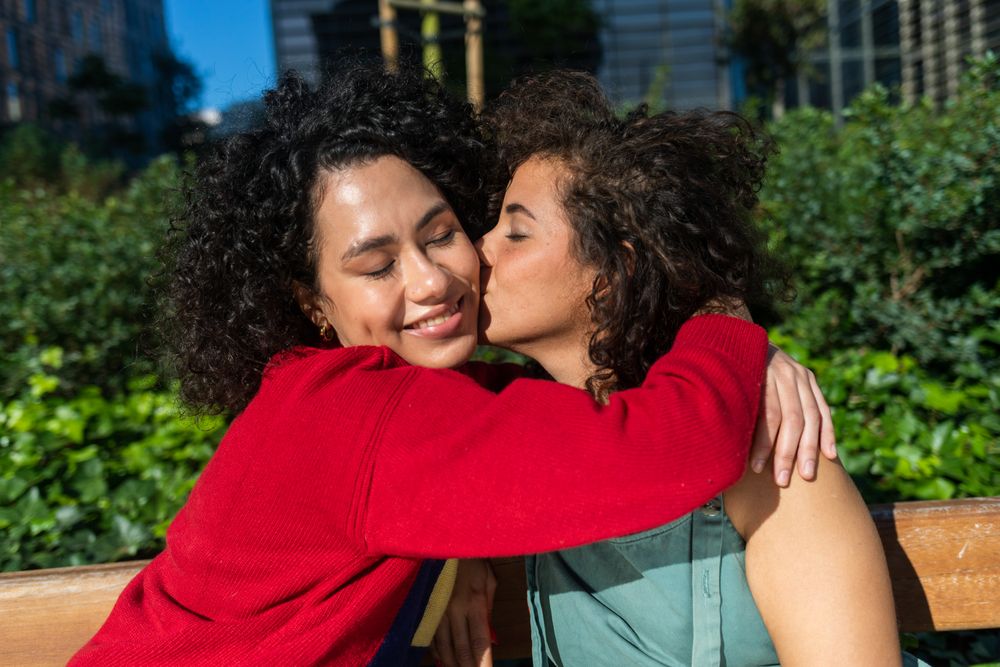 Happy female couple hugging in city park