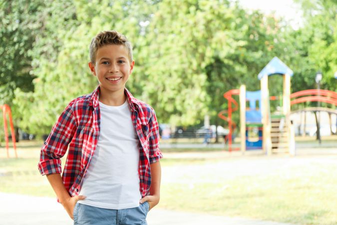 Boy against blurred playground background, space for text