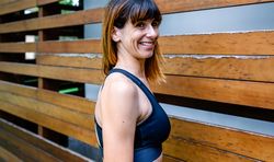 Cheerful female athlete in front of a wooden background