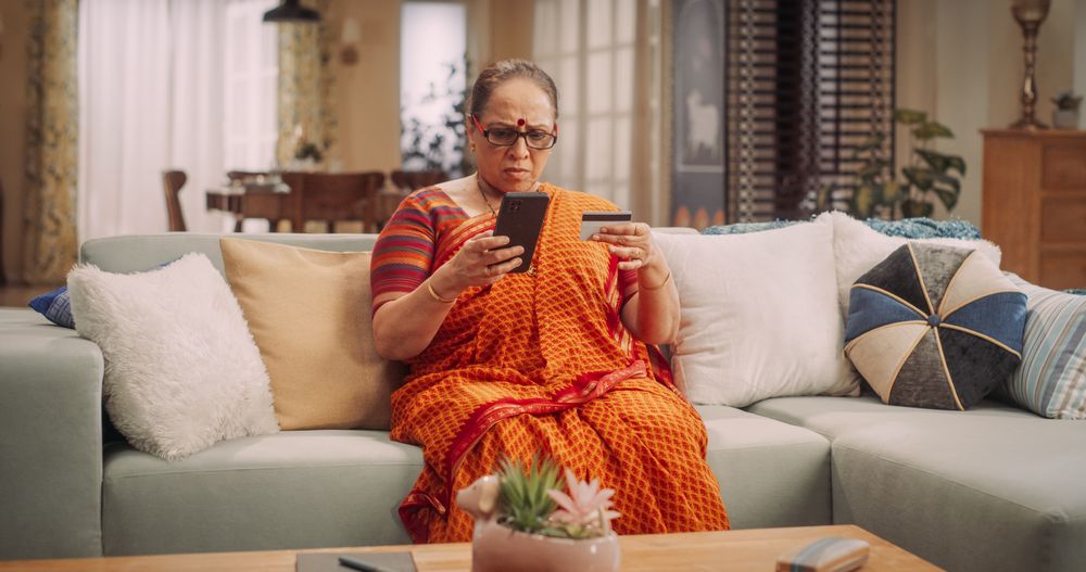 Mature Indian Woman Using Smartphone and Credit Card