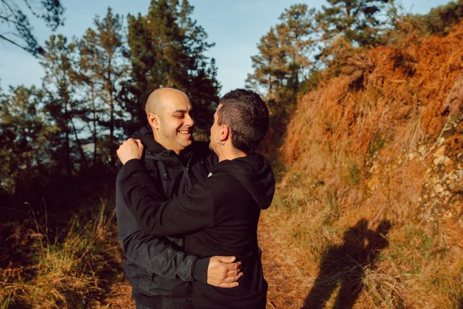 Men hugging and kissing in forest