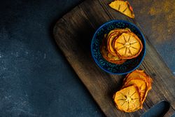 Top view of dried persimmon fruits on wooden board