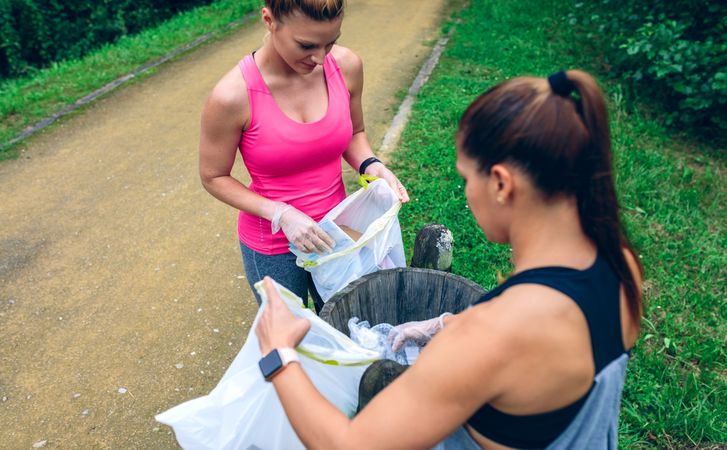 Two women throwing garbage after plogging