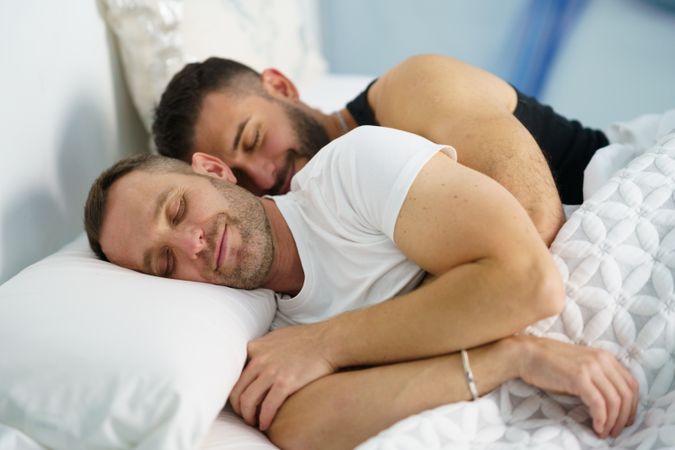 Cute male sleeping together in bed