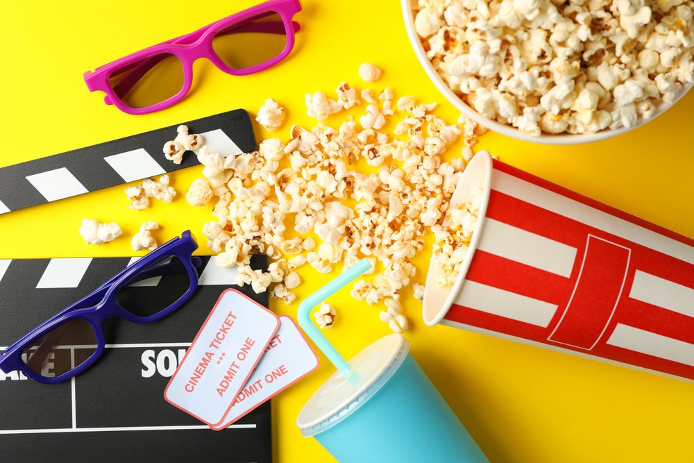 Flat lay composition with movie watching accessories on yellow background