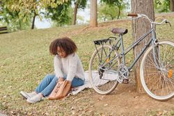 Young woman with vintage bicycle in park