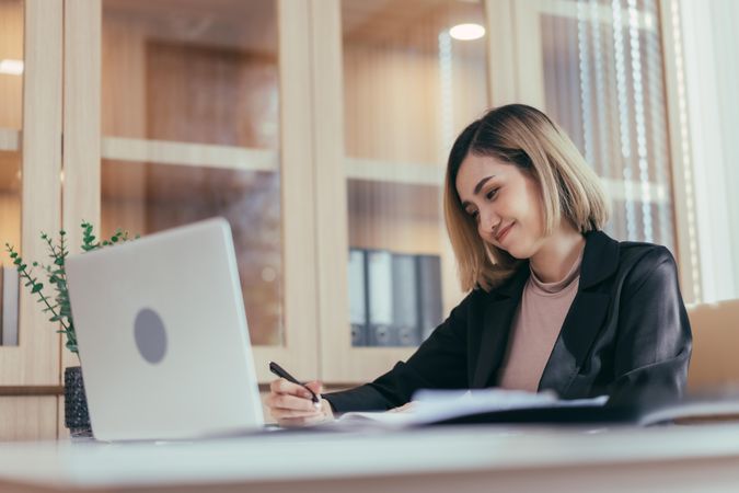 Female employee sitting in her office working on paperwork