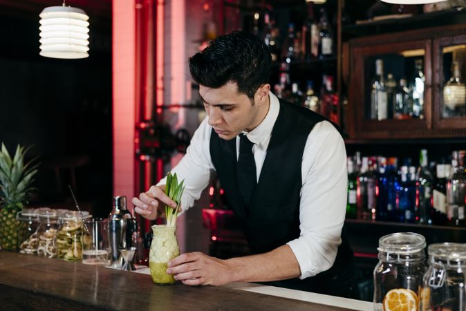 Barman working preparing drink in a glass