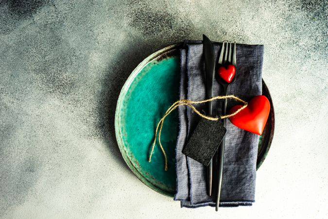 St. Valentine day card concept with teal plate with cutlery & hearts