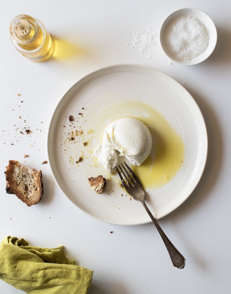 Plate with cheese near bread and condiments