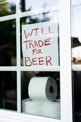 Sign from home asking to trade toilet paper for beer