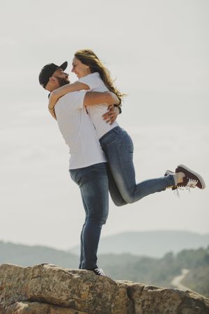 Loving couple embracing while standing at mountain cliff