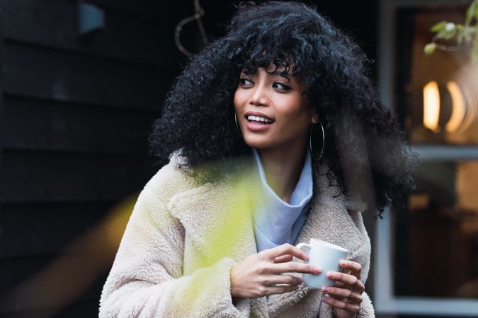 Smiling Black woman with cup of coffee
