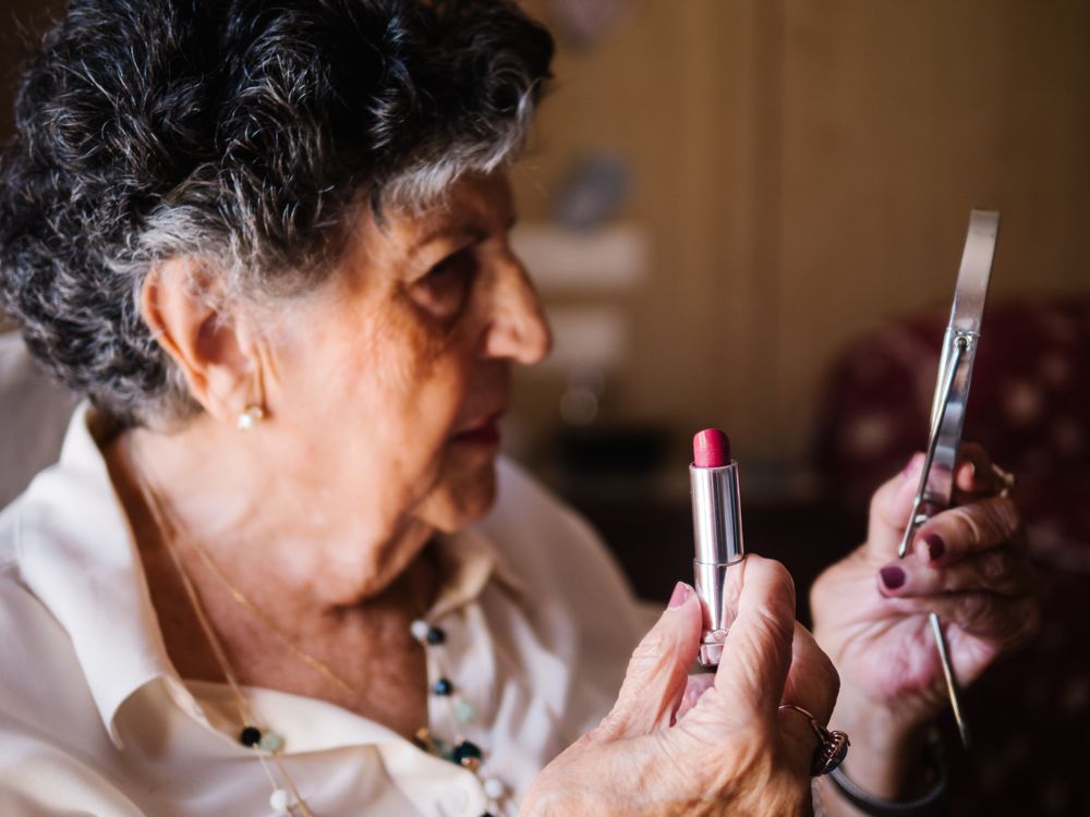 Older woman doing lips makeup at home