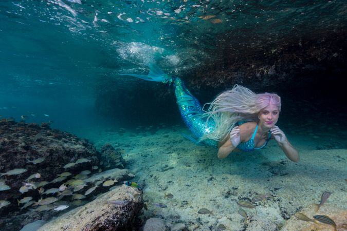 Redhead fairytale female mermaid swimming underwater