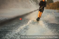 Man riding wakeboard on wave of motorboat in a lake 417780