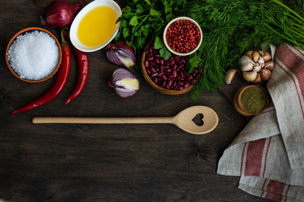 Top view of wooden table with kidney beans, chili and seasonings