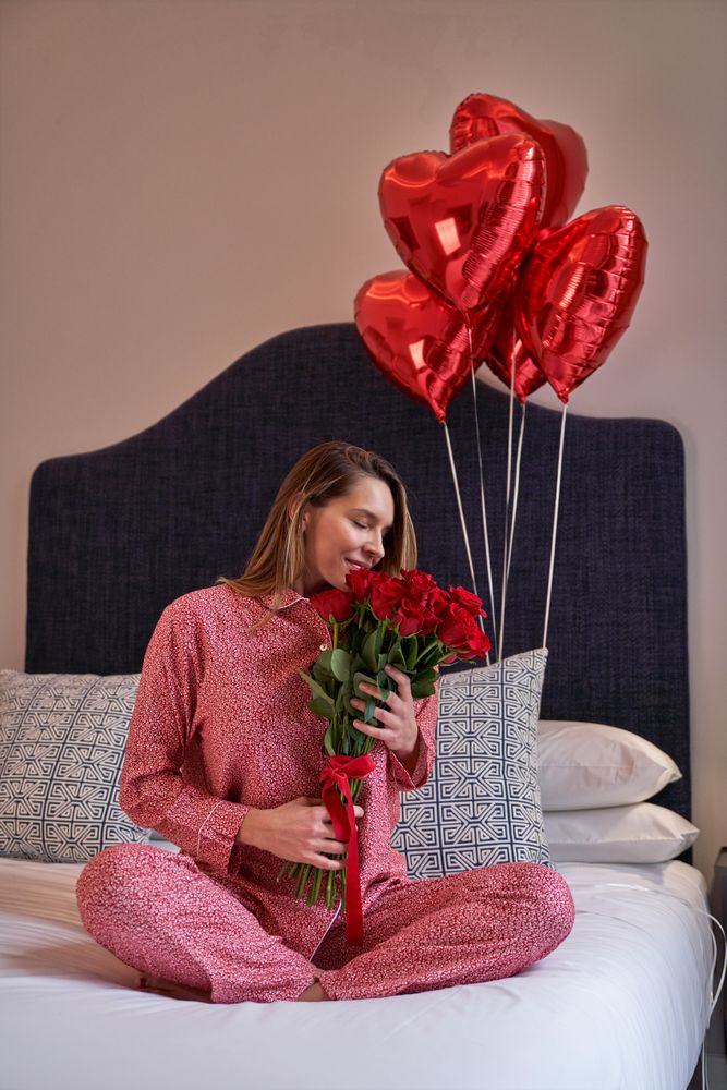 Happy female sniffing aromatic fresh bouquet of red roses