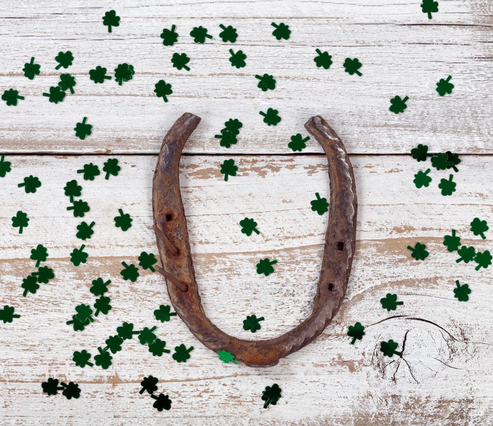 Rusty horseshoe with green shinny clovers for St Patrick Day