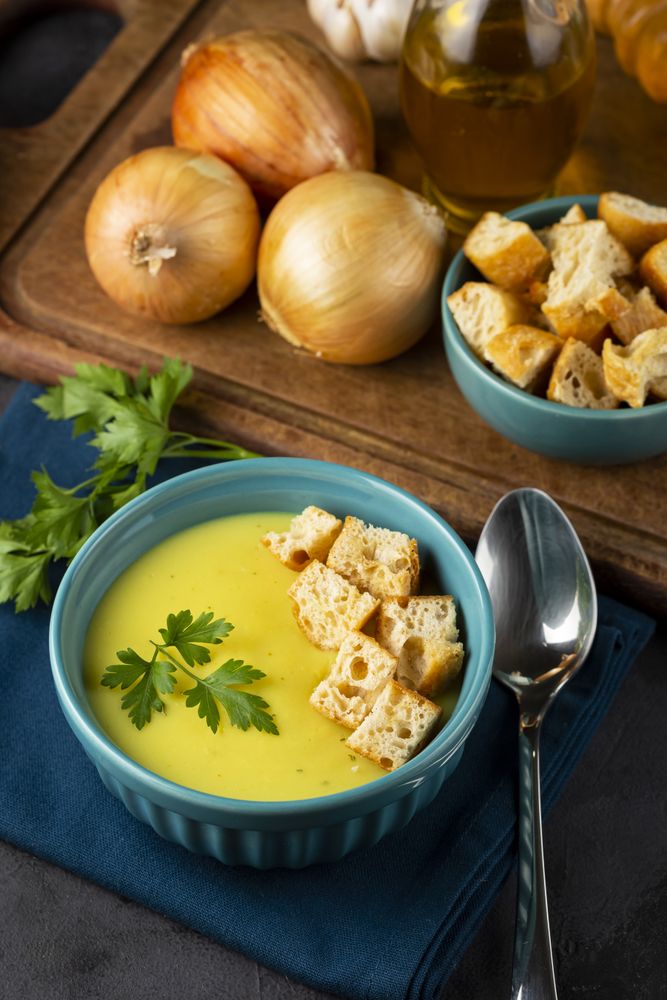 Bowl with onion soup and croutons on the table.
