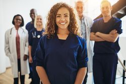 Smiling doctor with staff behind her
