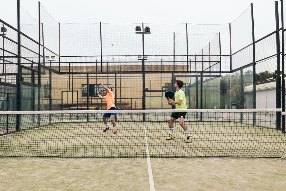 Two young man playing paddle tennis