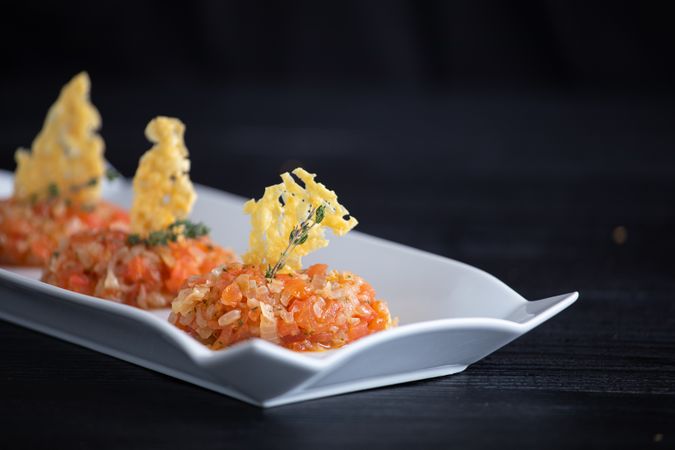 Tasty Quenelles of tomato fondue and Parmensan tile in ornamental plate