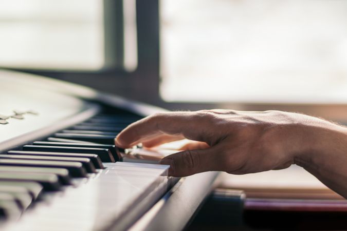 man playing piano with one hand. music keyboard