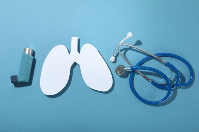 Lungs, inhaler, and stethoscope on blue background
