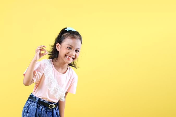 Happy Cheerful Girl Wearing Pink Shirt and Jeans, Laughing, and Make Okay Gesture.