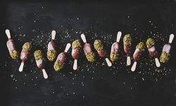 Ice cream chocolate pistachio popsicles, dark background, top view