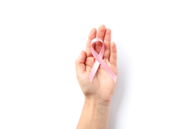 Female hand hold pink awareness ribbon, isolated on blank background