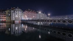 Illuminated buildings on city embankment in night