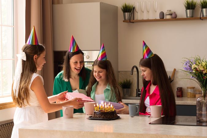 Family sharing gifts and joy during birthday celebration at home.