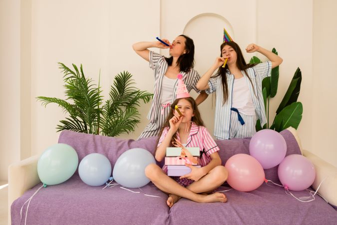 Laughing family with party blowers celebrating a birthday