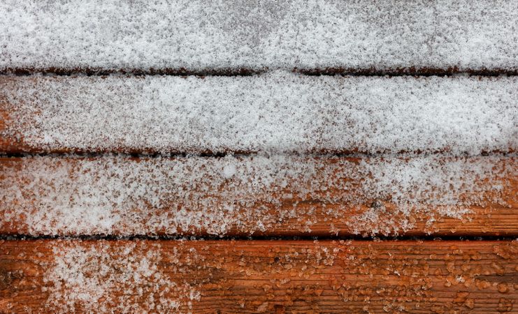 Outdoor deck wooden boards covered with snow and ice during winter