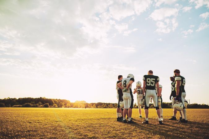 Football team standing in a circle and talking on a sports field