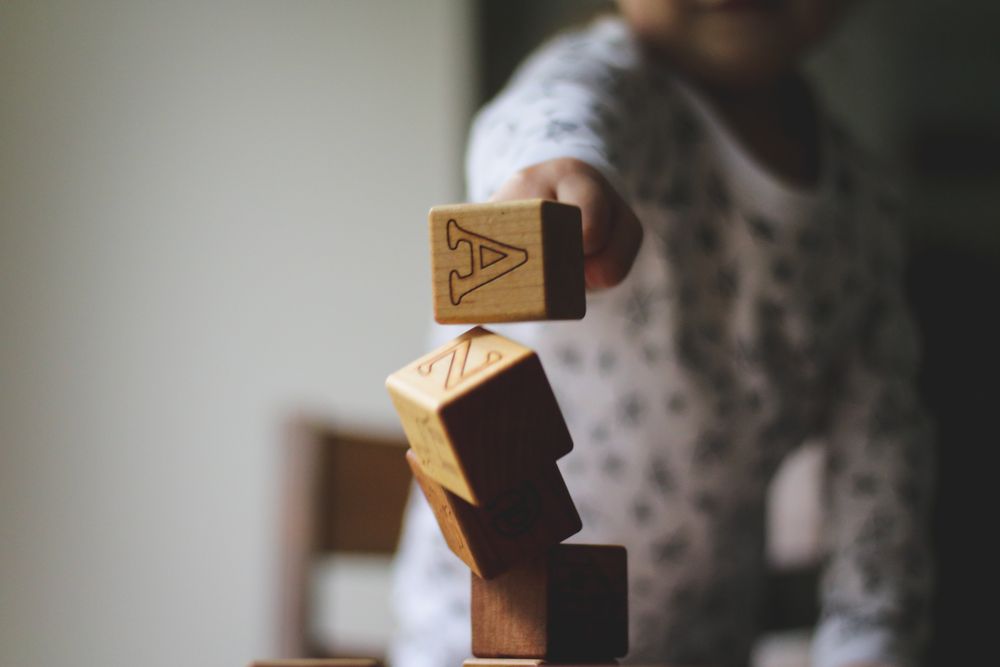 Child playing with wooden cubes that has letters on them