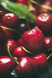Close up of freshly washed batch of cherries, vertical composition