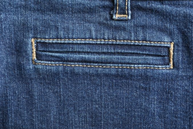 Closeup view of jeans pocket as background, space for text