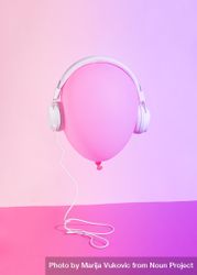 Pink balloon wearing headphones on pink background bDLJKb