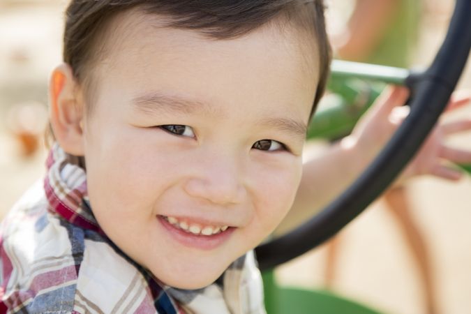 Young Biracial Boy Playing on Tractor