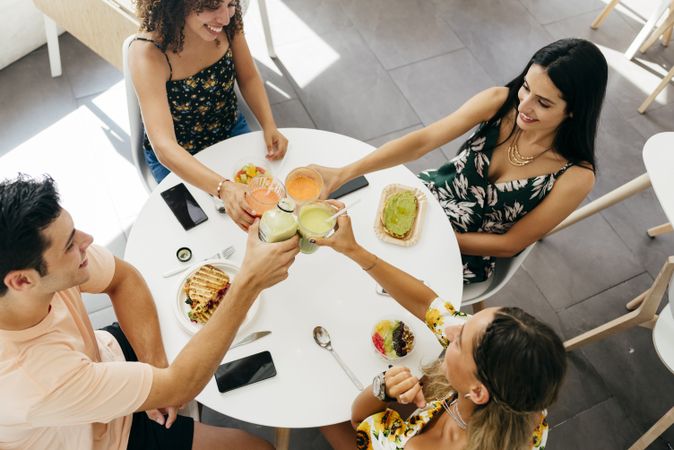 Diverse friends clinking glasses with smoothies